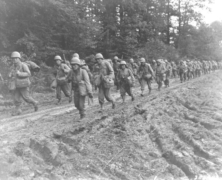 U.S. Army soldiers trudging up a dirt road in France, 1944