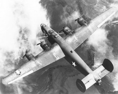 Overhead shot of a B-24 Liberator bomber flying above the clouds